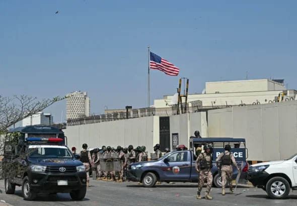 Personel keamanan berjaga di luar konsulat AS di Karachi pada 1 Maret 2026 selama bentrokan dengan Muslim Syiah saat mereka mencoba menyerbu gedung tersebut setelah kematian pemimpin tertinggi Iran Ayatollah Ali Khamenei di tengah serangan AS-Israel. Asif Hassan/AFP via Getty Images