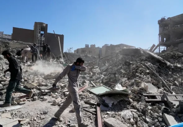 Sekelompok pria memeriksa reruntuhan kantor polisi yang diserang pada hari Senin di tengah kampanye militer AS-Israel di Teheran, Iran, pada 3 Maret 2026. Foto AP/Vahid Salemi